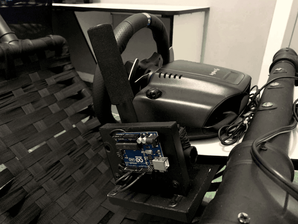 Close-up of the shifter mount with a custom Arduino board installed behind the wheel base